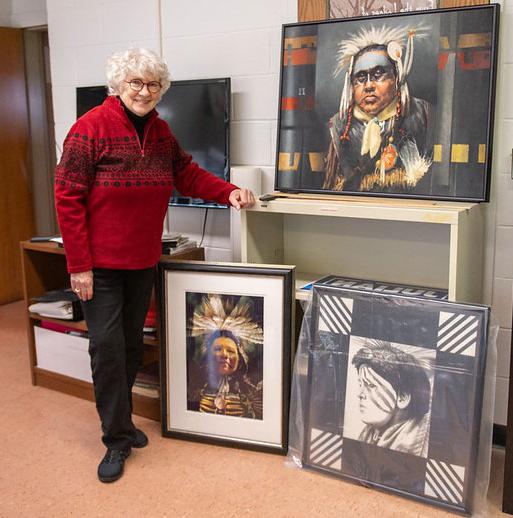 woman with glasses st和ing by paintings