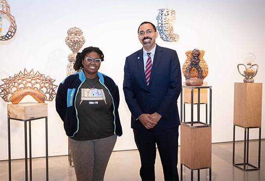 Man in shirt 和 tie with woman in front of art exhibit